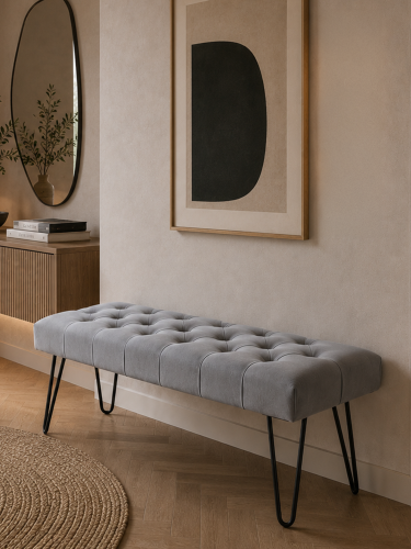 Banco gris con asiento capitoné y patas metálicas en forma de pasador de estilo loft