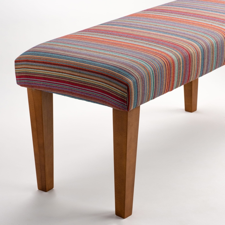 Banco tapizado de rayas sobre patas de madera