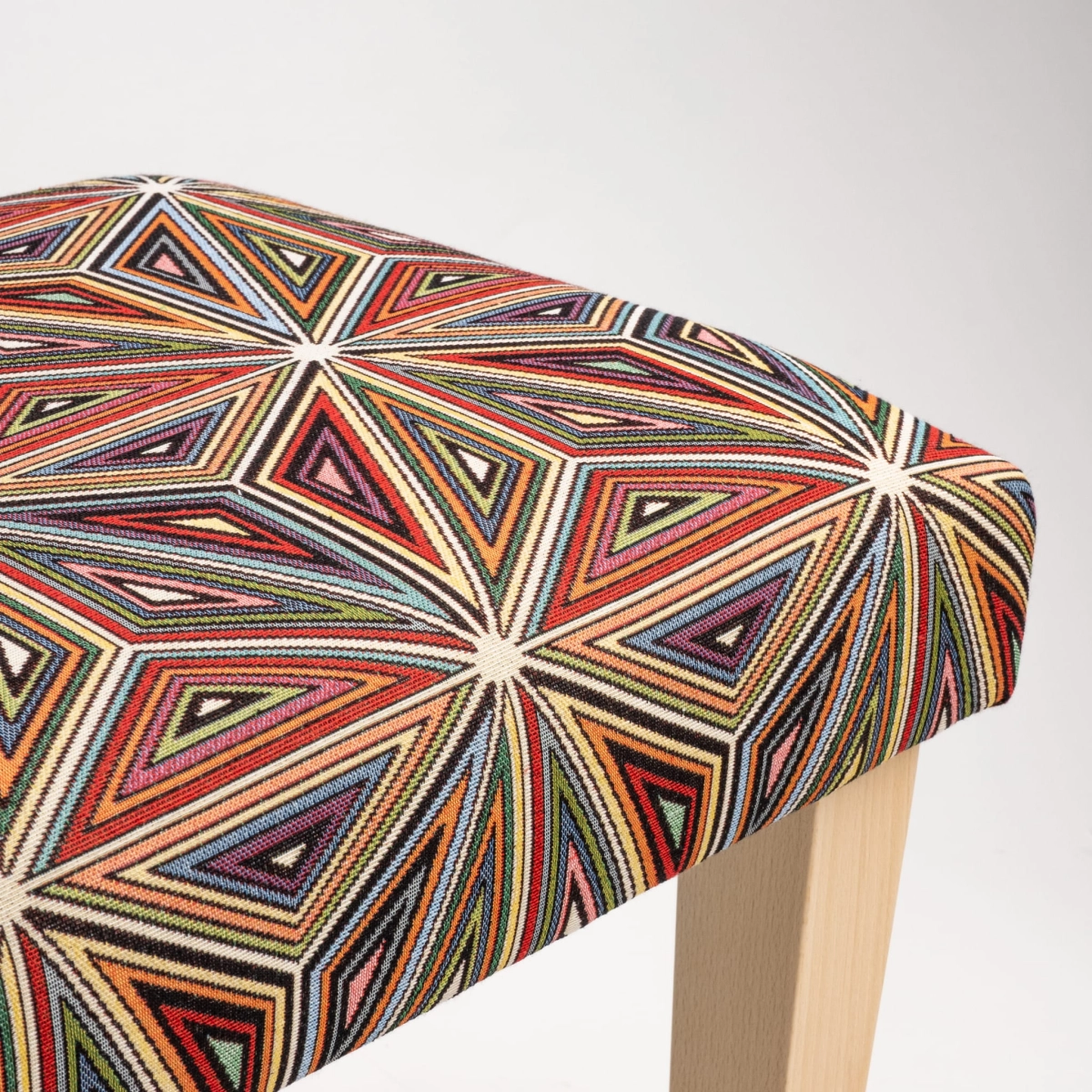Banco tapizado estampado sobre patas de madera