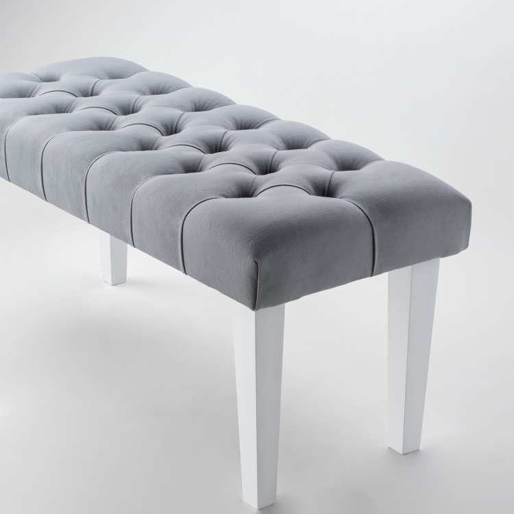 Elegante banco gris con tapizado acolchado y patas blancas