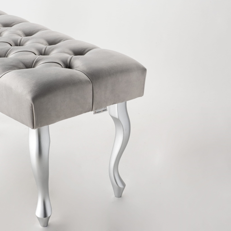 Banco tapizado en gris con patas de metal plateado