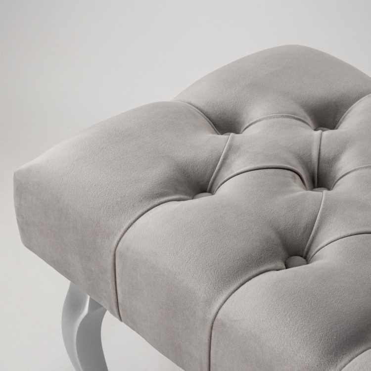 Elegante banco tapizado en gris con patas plateadas