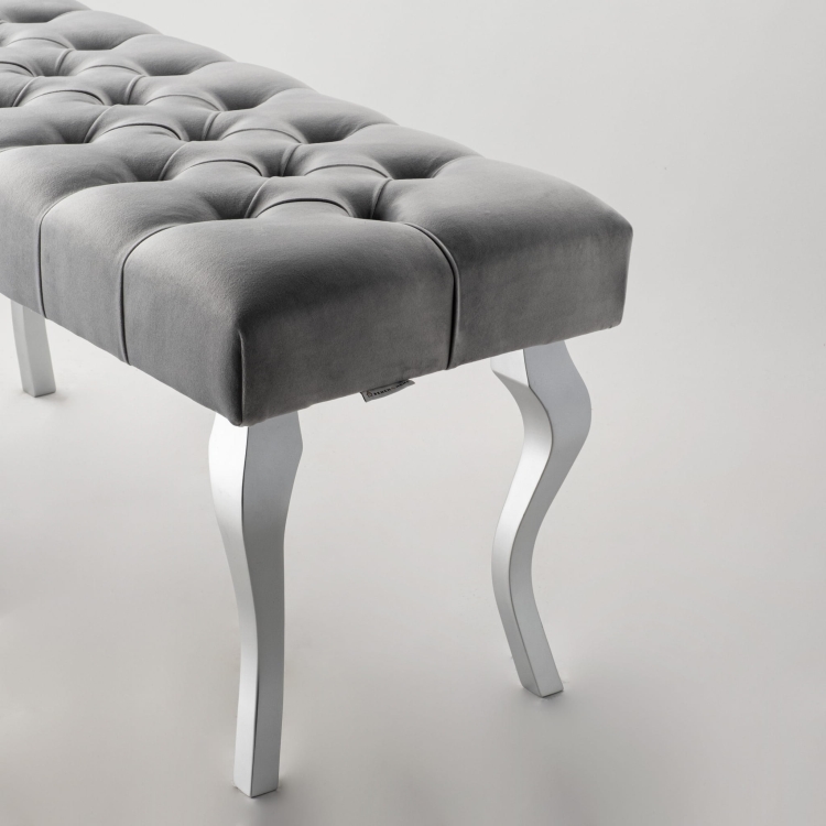 Banco gris acolchado con patas cromadas brillantes