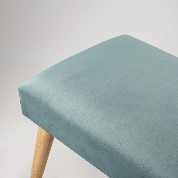 Elegante banco tapizado en menta con patas de madera