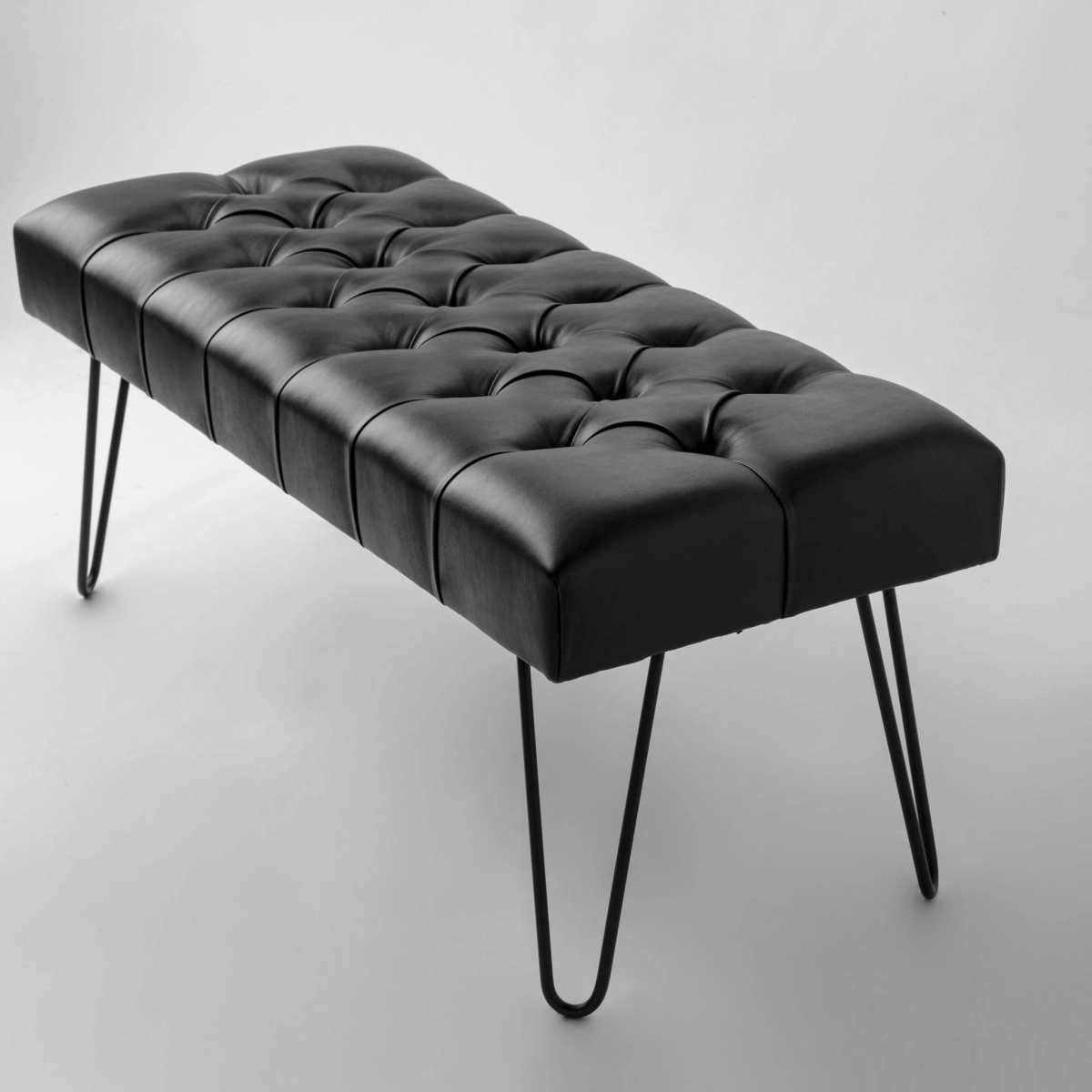 Banco de cuero negro sobre patas de metal