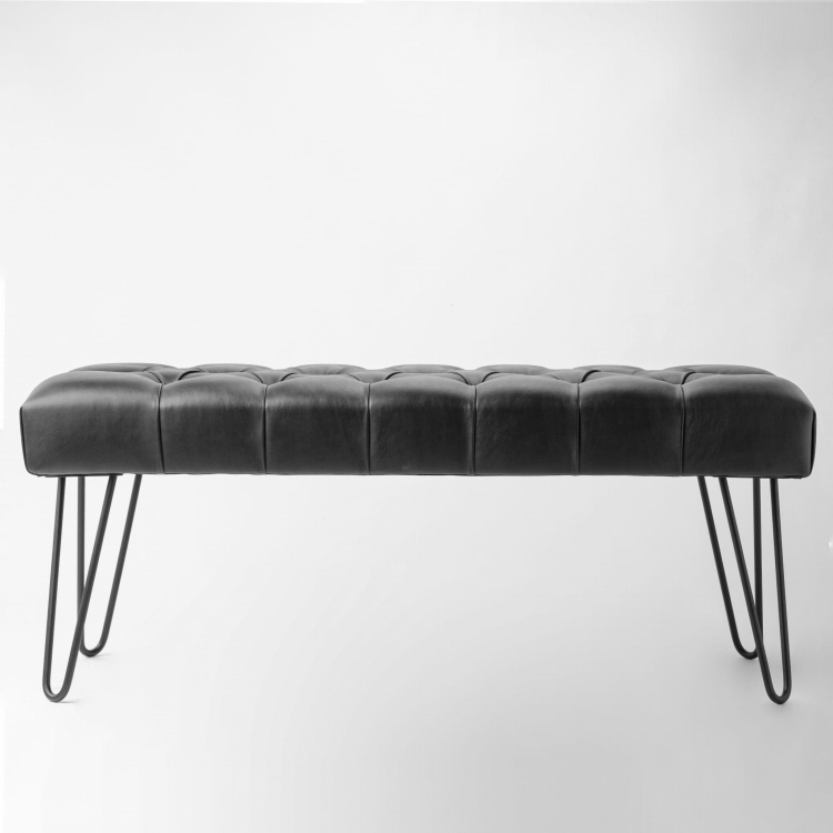 Banco de cuero negro sobre patas de metal