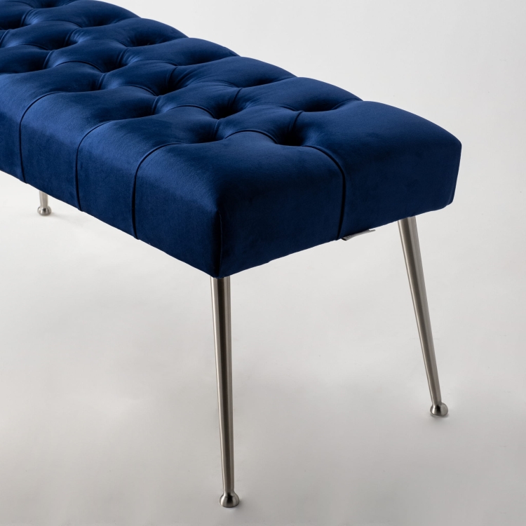 Banco acolchado azul marino con patas de metal, perfecto para interiores estilo loft