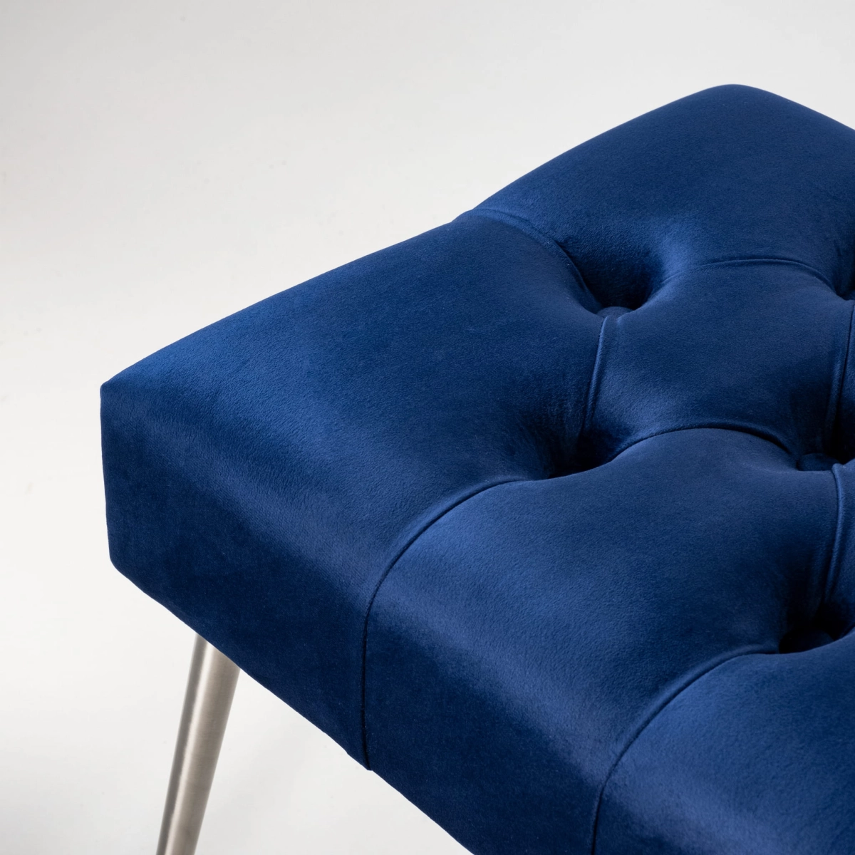 Banco acolchado azul marino con patas de metal