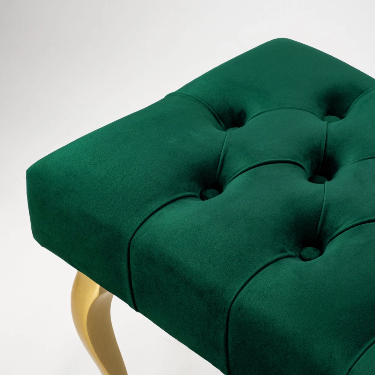Elegante banco capitoné con patas doradas en color verde botella