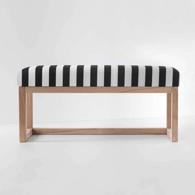 Banco tapizado de rayas blancas y negras con un estante y estructura de madera clara
